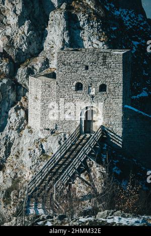 Vertikale Aufnahme einer Burg im schneebedeckten Berg Stockfoto