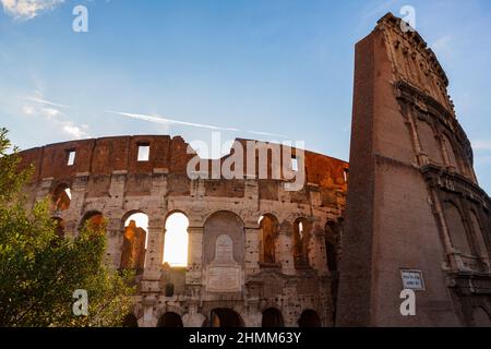 Die Sonne geht an einem wolkenlosen Sommertag auf dem Kolosseum in Rom, Italien, dem größten antiken Amphitheater, das je erbaut wurde, unter. Stockfoto