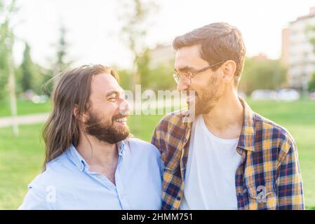 Fröhliches schwule Paar, das sich im Park ansieht Stockfoto
