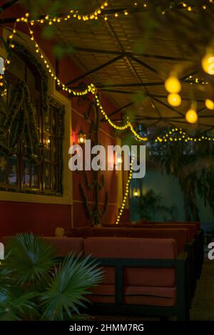 Weihnachtsdekorationen in der Bar. Gelbe Girlanden an den Wänden. Frohes neues Jahr. Weihnachtslichter im Restaurant, Lampen. Hochwertiges Foto Stockfoto