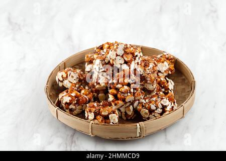 Brondong Jagd oder Bororndong, javanesischer traditioneller Snack Süßer Popcorn mit klebriger Palmzucker. Auf Bamboo Plate Stockfoto