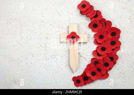 Anzac Tag. Nationaler Feiertag oder Gedenktag in Australien und Neuseeland. Rote Mohnblumen und Kreuz auf Bienenstein Hintergrund Stockfoto