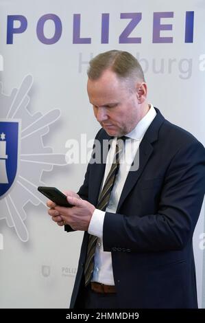 Hamburg, Deutschland. 10th. Februar 2022. Andy Grote (SPD), Senator für Inneres und Sport, steht im Polizeihauptquartier und schaut nach der Vorlage der Kriminalitätsstatistik 2021 auf sein Handy. Die Kriminalität in Hamburg ist zum sechsten Mal in Folge zurückgegangen. Kredit: Marcus Brandt/dpa/Alamy Live Nachrichten Stockfoto