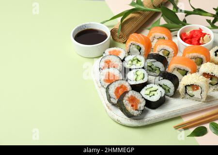 Konzept von leckeren Speisen mit Sushi-Rollen auf zweifarbigem Hintergrund Stockfoto