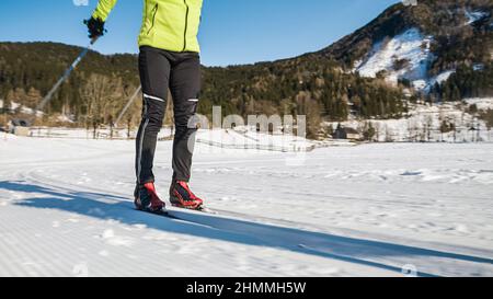 Männer üben Skifahren als Sport und Freizeitbeschäftigung, Elemente der Skate-Langlauf-Technik. Stockfoto