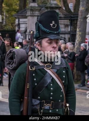 Der in Battle of Waterloo-Uniform gekleidete Schauspieler blickt nach unten, während er in der Lord Mayor-Show 2021, Victoria Embankment, London, marschiert. Stockfoto