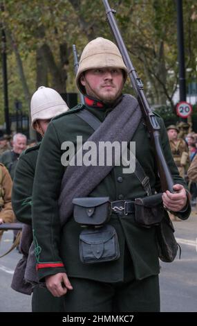 Der in einer alten Uniform der britischen Armee mit weißem Helm gekleidete Reenaktor, der ein Gewehr trägt, blickt nach vorne, während er in der Lord Mayor Show 2021 in London marschiert. Stockfoto