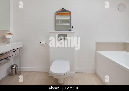 Newport, Essex - Juli 10 2018: Minimalistisches Luxus weiß gestrichenes Badezimmer mit Waschbecken, Badewanne und Toilette Stockfoto