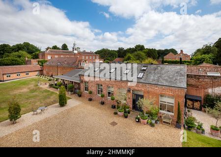 Newport, Essex - Juli 10 2018: Altes Nebengebäude des Landhauses, das in ein luxuriöses Backsteinhaus mit bezaubernden Landschaftsgärten umgewandelt wurde. Stockfoto