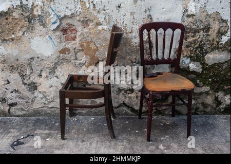 14.06.2021, Singapur, Republik Singapur, Asien - zwei alte und weggeworfene Stühle stehen am Straßenrand vor einer Hauswand in Little India. Stockfoto
