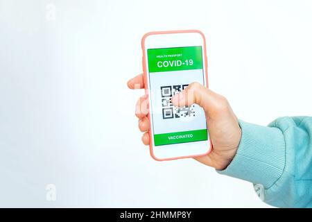 Covid-19 Gesundheitspass. Geimpfte Person mit digitaler Gesundheitspass-App im Mobiltelefon mit Impfpass covid-19 Stockfoto