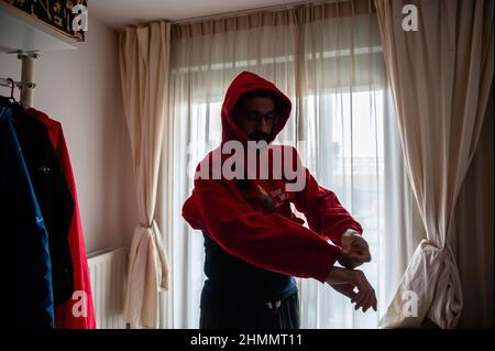 Nijmegen, Niederlande. 10th. Februar 2022. Ein Mann wird gesehen, wie er einen gemütlichen Pullover anzieht, nachdem er die Heizung heruntergedreht hat.der Warm Sweater Day wird jedes Jahr an einem Freitag im Februar vom Klimaatverbond Nederland (Climate Association Netherlands) organisiert, einem Zusammenschluss öffentlicher Organisationen mit Ambitionen im Bereich Nachhaltigkeit und Klimawandel. Es handelt sich um eine nationale Klimaschutzmaßnahme, bei der alle Teilnehmer versprechen, die Heizung in ihren Häusern, Büros, am Arbeitsplatz oder in ihren Klassenzimmern zu senken. Anstatt den Raum zu erhitzen, heizen sie sich selbst auf, indem sie ein Komf tragen Stockfoto