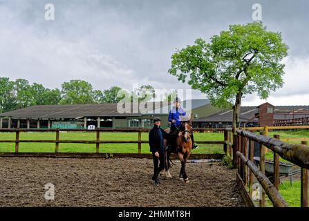 Mädchen mit ihrem ersten Reitunterricht bareback mit Helm und Ausbilder. Wellington Riding School, Hook, Vereinigtes Königreich. 11.05.2016 Stockfoto