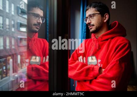 Nijmegen, Niederlande. 10th. Februar 2022. Ein Mann wird zu Hause durch das Fenster gesehen, während er einen warmen Pullover trägt, nachdem er die Heizung heruntergedreht hat.der Warm Sweater Day wird jedes Jahr an einem Freitag im Februar vom Klimaatverbond Nederland (Climate Association Netherlands) organisiert. Das ist ein Zusammenschluss öffentlicher Organisationen mit Ambitionen im Bereich Nachhaltigkeit und Klimawandel. Es handelt sich um eine nationale Klimaschutzmaßnahme, bei der alle Teilnehmer versprechen, die Heizung in ihren Häusern, Büros, am Arbeitsplatz oder in ihren Klassenzimmern zu senken. Statt den Raum zu erhitzen, wird die Stockfoto