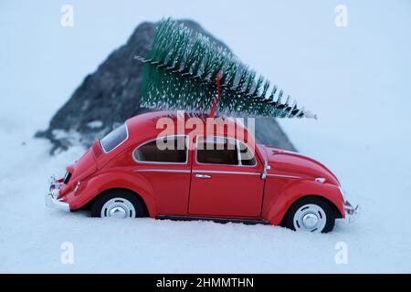 Kostanay, Kasachstan 2022.Roter Volkswagen Käfer mit Fichte auf dem Dach, der im Schnee stecken geblieben ist Stockfoto