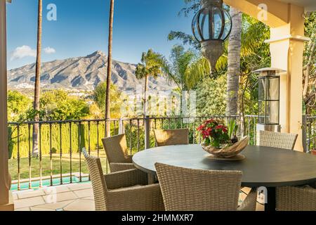 Blick auf einen Esstisch von einer Villa-Terrasse mit Blick auf die Berge von Marbella an der Costa del Sol Stockfoto