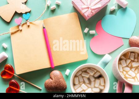 Grußkarte zum valentinstag auf dem Hintergrund der Herzen und ein leeres Notizbuch Stockfoto