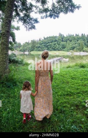Mutter und Tochter auf dem Weg zum Steg am Meer Stockfoto