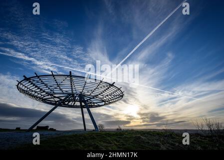 Haslingden, Lancashire, Großbritannien, Mittwoch, 09. Februar 2022. Ein Spaziergänger hält an, um die untergehende Sonne am Halo panopticon über der Stadt Haslingden zu bewundern, Stockfoto