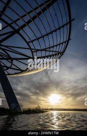 Haslingden, Lancashire, Großbritannien, Mittwoch, 09. Februar 2022. Ein Spaziergänger hält an, um die untergehende Sonne am Halo panopticon über der Stadt Haslingden zu bewundern, Stockfoto