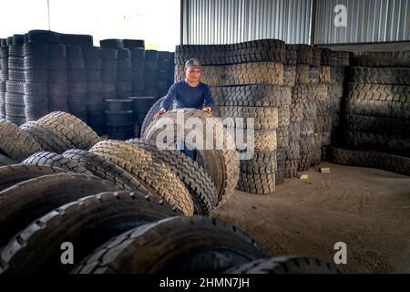 Son Tinh, Quang Ngai, Vietnam - 31. Dezember 2021: Arbeiter arbeiten in einer alten Autoreifen-Recyclingfabrik im Bezirk Son Tinh, Provinz Quang Ngai, Vietna Stockfoto