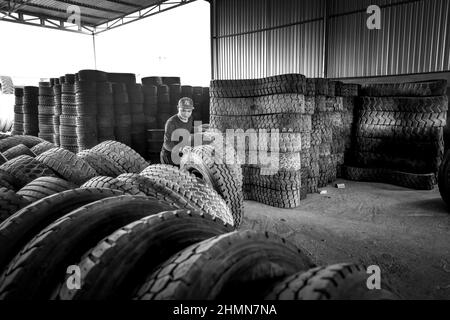 Son Tinh, Quang Ngai, Vietnam - 31. Dezember 2021: Arbeiter arbeiten in einer alten Autoreifen-Recyclingfabrik im Bezirk Son Tinh, Provinz Quang Ngai, Vietna Stockfoto