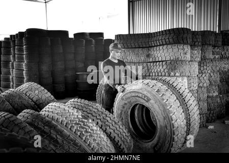 Son Tinh, Quang Ngai, Vietnam - 31. Dezember 2021: Arbeiter arbeiten in einer alten Autoreifen-Recyclingfabrik im Bezirk Son Tinh, Provinz Quang Ngai, Vietna Stockfoto