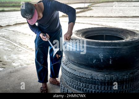 Son Tinh, Quang Ngai, Vietnam - 31. Dezember 2021: Arbeiter arbeiten in einer alten Autoreifen-Recyclingfabrik im Bezirk Son Tinh, Provinz Quang Ngai, Vietna Stockfoto