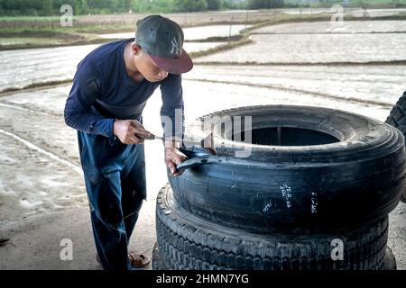 Son Tinh, Quang Ngai, Vietnam - 31. Dezember 2021: Arbeiter arbeiten in einer alten Autoreifen-Recyclingfabrik im Bezirk Son Tinh, Provinz Quang Ngai, Vietna Stockfoto