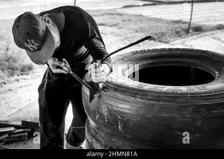 Son Tinh, Quang Ngai, Vietnam - 31. Dezember 2021: Arbeiter arbeiten in einer alten Autoreifen-Recyclingfabrik im Bezirk Son Tinh, Provinz Quang Ngai, Vietna Stockfoto