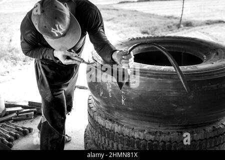 Son Tinh, Quang Ngai, Vietnam - 31. Dezember 2021: Arbeiter arbeiten in einer alten Autoreifen-Recyclingfabrik im Bezirk Son Tinh, Provinz Quang Ngai, Vietna Stockfoto