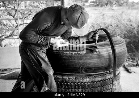 Son Tinh, Quang Ngai, Vietnam - 31. Dezember 2021: Arbeiter arbeiten in einer alten Autoreifen-Recyclingfabrik im Bezirk Son Tinh, Provinz Quang Ngai, Vietna Stockfoto