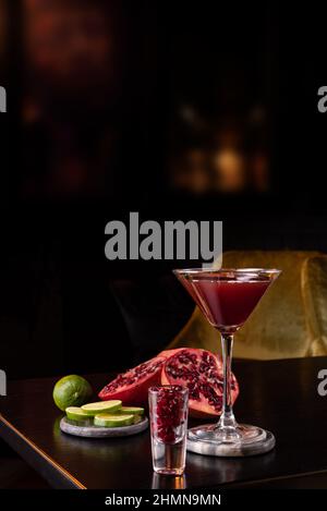 Granatapfel-Martini in einer Nachtclubbar, garniert mit frischem Obst Stockfoto