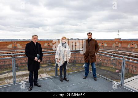 Nürnberg, Deutschland. 11th. Februar 2022. Ministerpräsident Markus Söder (CSU, r) inspiziert zusammen mit dem Direktor der Stiftung Bayerische Gedenkstätten und dem Vizepräsidenten des Bayerischen Landtags Karl Freller (l.) und der Nürnberger Bürgermeisterin Dr. Julia Lehner (M) das Kongresshaus auf dem ehemaligen Parteitagsgelände. Hier stehen die drei auf einer Plattform im Innenhof der Kongresshalle. Quelle: Daniel Löb/dpa/Alamy Live News Stockfoto