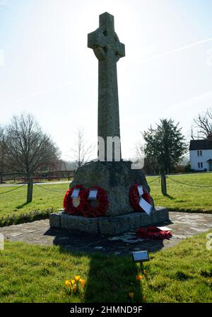 War Memorial bei Staplefield Green in West Sussex. Ein christliches Kreuz mit Mohnkränzen unten. Stockfoto