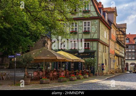 Straßencafé und historische Fachwerkarchitektur am Kornmarkt in der Altstadt von Quedlinburg, Sachsen-Anhalt, Deutschland. Stockfoto