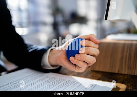 Nahaufnahme des Kaufmanns Holding Stress Ball in Hand Stockfoto