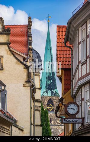 Quedlinburg, Sachsen-Anhalt, Deutschland: Blick über die schmale Gasse der Bockstraße auf einen der Kirchtürme der Nikolaikirche in der Altstadt. Stockfoto