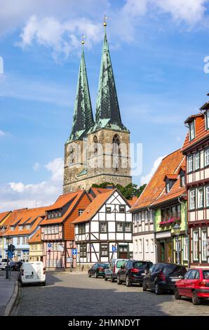 Quedlinburg, Sachsen-Anhalt, Deutschland: Stationärer Verkehr, historische, denkmalgeschützte Fachwerkhäuser in der Pölkenstraße und Blick auf die Nikolaikirche. Stockfoto