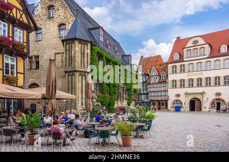 Quedlinburg, Sachsen-Anhalt, Deutschland: Gut besuchtes Straßencafé direkt neben dem mittelalterlichen Rathaus auf dem historischen Marktplatz in der Altstadt. Stockfoto