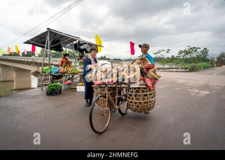 Provinz Binh Dinh, Vietnam - 3. Januar 2022: Ein Landwirt verkauft handgefertigte Öfen, die auf einem alten Fahrrad in der Provinz Binh Dinh, Vietnam, transportiert werden Stockfoto