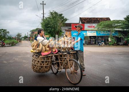 Provinz Binh Dinh, Vietnam - 3. Januar 2022: Ein Landwirt verkauft handgefertigte Öfen, die auf einem alten Fahrrad in der Provinz Binh Dinh, Vietnam, transportiert werden Stockfoto