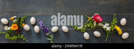 Frohe Ostern. Wachtelei und Frühlingsblumendekoration, blauer Holztischhintergrund, Draufsicht, Kopfzeile. Grußkartenvorlage Stockfoto