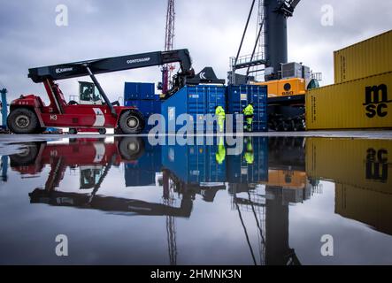 Mukran, Deutschland. 11th. Februar 2022. Im Hafen von Mukran wird nach der Ankunft des ersten Schiffes einer neuen "Seidenstraße"-Verbindung zwischen China und Deutschland ein Container entladen. Die Container aus dem chinesischen Wuhan decken einen Teil der Strecke auf dem Wasser ab und werden auf der Insel Rügen wieder auf Schienenfahrzeuge verladen. Quelle: Jens Büttner/dpa-Zentralbild/dpa/Alamy Live News Stockfoto