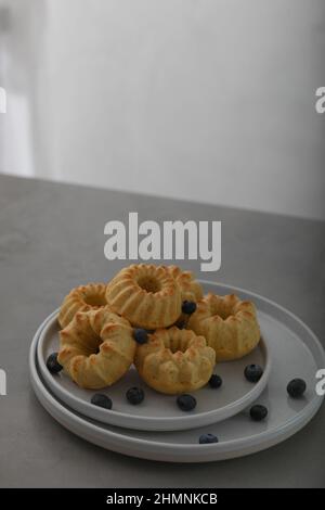 Mini-gebundener Kuchen mit Früchten auf Teller auf einem grauen Tisch. Frühstück. Speicherplatz kopieren Stockfoto