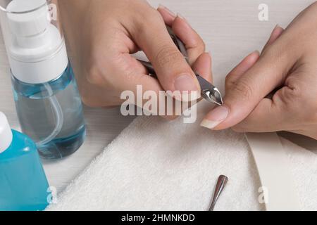 Eine Frau macht eine Maniküre zu Hause. Maniküre-Werkzeuge. Maniküre mit Kanten. Gefährliche Maniküre. Häusliche Pflege, Spa, Schönheit. Nagelstudio Stockfoto