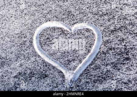 Schwarzer Ruß aus dem Kesselraum auf weißem Schnee. Natürlicher Hintergrund. Schnee gemischt mit Kohleroß, schlechte Ökologie. Umweltverschmutzung. Ein Herz ist schmerzhaft Stockfoto