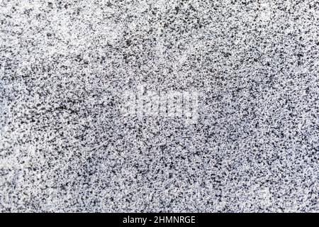 Schwarzer Ruß aus dem Kesselraum auf weißem Schnee. Natürlicher Hintergrund. Schnee gemischt mit Kohleroß, schlechte Ökologie. Umweltverschmutzung Stockfoto