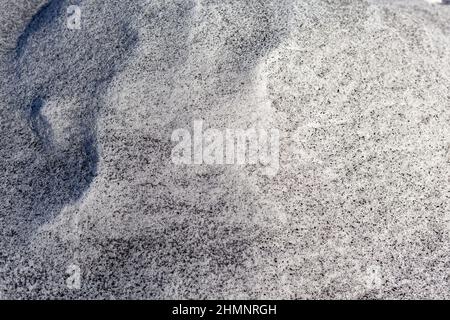 Schwarzer Ruß aus dem Kesselraum auf weißem Schnee. Natürlicher Hintergrund. Schnee gemischt mit Kohleroß, schlechte Ökologie. Umweltverschmutzung Stockfoto
