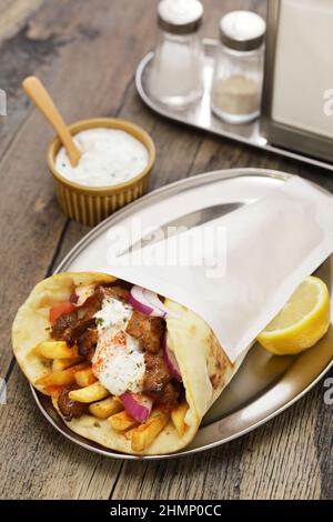 Hausgemachtes Schweinefleisch Gyros (Pita Wrap Sandwich) mit Tsatziki (Joghurt-Sauce), griechische Küche Stockfoto
